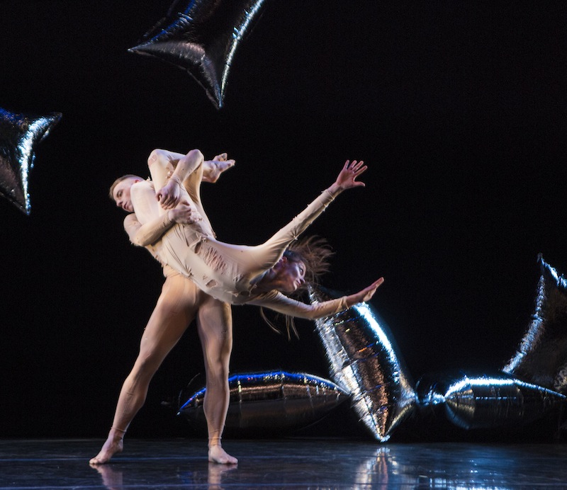 Melissa Toogood and Nicholas Scisione in RainForest. Scisione lifts Toogood upside down. She dangles dangerously.